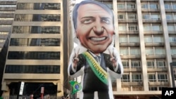 Supporters of Jair Bolsonaro, presidential candidate for the National Social Liberal Party who was stabbed during a campaign event days ago, exhibit a large, inflatable doll in his image in Sao Paulo, Brazil, Sept. 9, 2018.