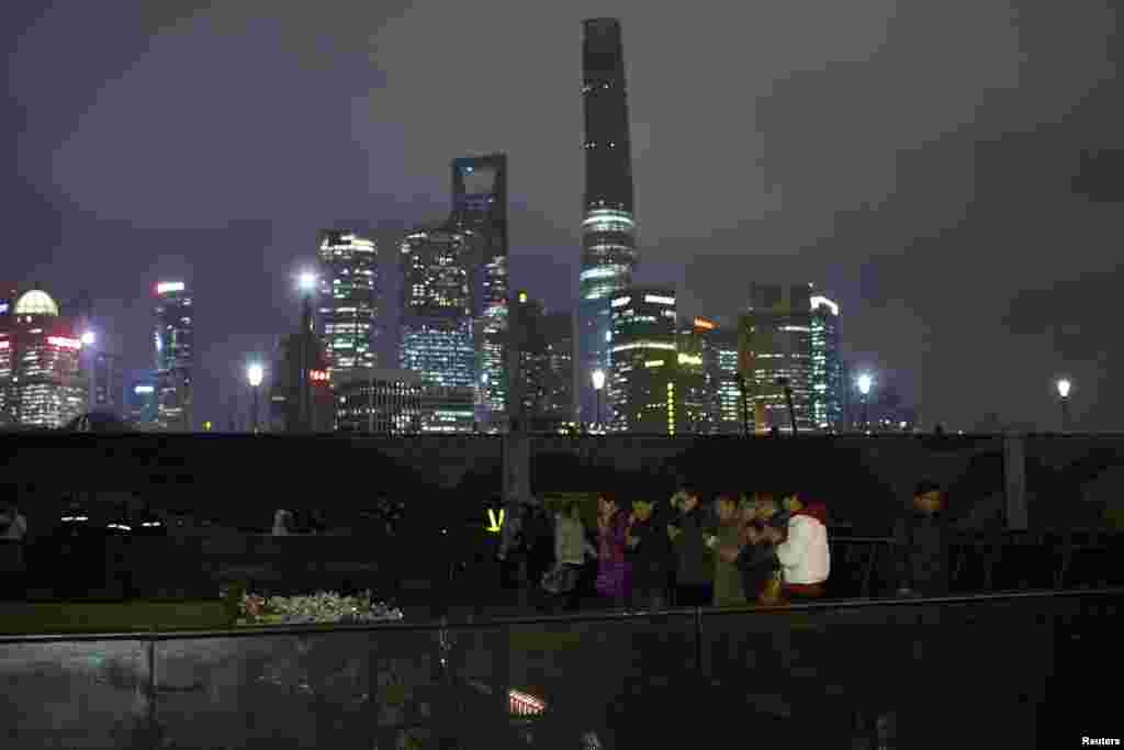 People offer prayers during a memorial ceremony for people who were killed in a stampede incident during the New Year celebrations at the Bund, in Shanghai, China, Jan. 6, 2015.