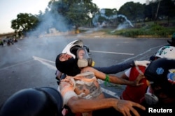 An injured opposition supporter is helped by volunteer members of a primary care response team during clashes with riot security forces at a rally against Venezuelan President Nicolas Maduro's government in Caracas, Venezuela, June 22, 2017.