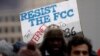 A protester holds a sign that reads "Resist the FCC. Text: INTERNET To: 52886" at the Federal Communications Commission (FCC), in Washington, Dec. 14, 2017.