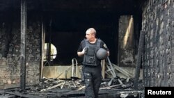 A law enforcement officer walks at the site of a burnt house, which is reportedly owned by former Governor of the Ukrainian Central Bank Valeria Gontareva, in Kyiv, Ukraine, Sept. 17, 2019.