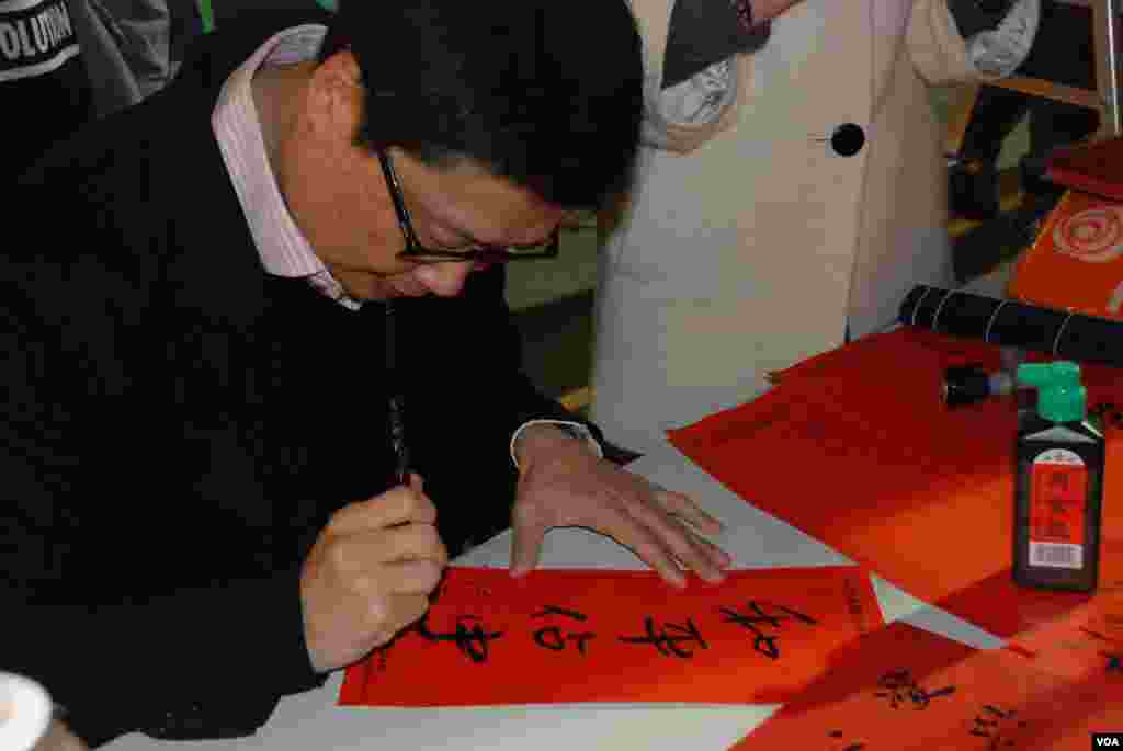 Chan Kin Man, co-organizer of the Occupy Central movement, writes calligraphy at the pan-democracy parties&rsquo; vending stall.