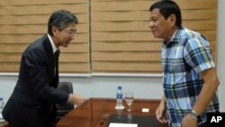 President-elect Rodrigo Duterte, right, receives Ambassador Kazuhide Isihikawa of Japan during a visit at Davao city hall, May 16, 2016. Duterte said Monday he would reimpose the death penalty, and target corruption after winning last week's election based on an unofficial count. (Office of the City Mayor Davao City via AP) 