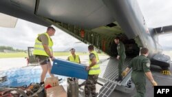 Privates load water bottles and other relief into a French Army logistical transport plane bound for Vanuatu, at the Aerial Military Base Lieutenant Paul Klein (formerly known as La Tontouta), north of Noumea, New Caledonia, on March 15, 2015. 