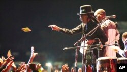 Popular Zimbabwean musician Thomas Mapfumo throws out cds to fans during his performance in Harare, April, 29, 2018, after returning from exile in the United States to perform protest songs in front of tens of thousands of people on the outskirts of the capital,