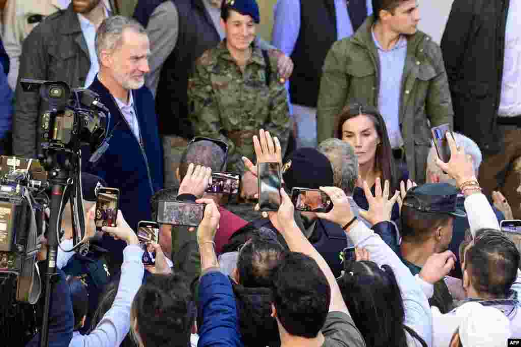 Residents take photos of Spain&#39;s King Felipe VI (L) and Queen Letizia as they visit the flood damaged town of Chiva, in the region of Valencia, eastern Spain, in the aftermath of catastrophic deadly floods.&nbsp;The King and Queen are returning to visit the area after they were heckled by angry residents during their first visit to the Valencia region where catastrophic floods in October left at least 226 people dead, according to officials.&nbsp;