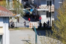 Members of a Roma community gather on the street after several cases of the coronavirus were detected, in Larissa, Greece, April 10, 2020.