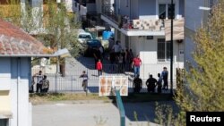 FILE - Members of a Roma community gather on the street after several cases of the coronavirus were detected, in Larissa, Greece, April 10, 2020.