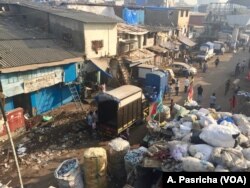 A street along Mumbai's Dharavi slum in India is littered with waste that includes plastic items and bags.