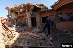 A Christian man inspects his neighbors' home, destroyed by Islamic State militants in the Christian city of Qaraqosh, Iraq, Sept. 12, 2018.