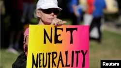 FILE - Lori Erlendsson attends a pro-net neutrality Internet activist rally in the neighborhood where President Barack Obama attended a fundraiser in Los Angeles, California, July 2014.