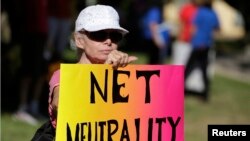 一位女士在加州参加支持“网络中立”的集会，当时奥巴马正在附近参加一次募款活动。（2014年7月资料照）