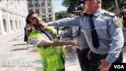 Polis jurnalisti döyərkən 