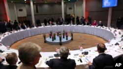 PM Inggris, Theresa May, kedua dari kiri, berjalan melintasi para pemimpin Uni Eropa yang tengah duduk unuk sebuah pertemuan makan malam di pertemuan puncak Uni Eropa, 28 Mei 2019 (foto: AP Photo/Fransisco Seco, Pool)