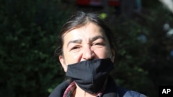FILE - In this May 24, 2020, photo, Muyesser Yildiz wears a face mask to protect against the coronavirus as she visits a public garden, in Ankara, Turkey.