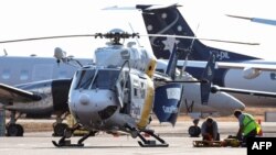 Helikopter Care Flight di landasan Bandara Internasional Darwin di Darwin pada 27 Agustus 2023, bersiap mengevakuasi marinir AS yang terluka dalam kecelakaan pesawat militer US Osprey di sebuah pulau terpencil di Australia. (Foto: AFP)