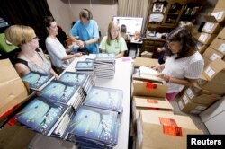 Employees unbox "Go Set A Watchman" at Ol' Curiosities & Book Shoppe in Monroeville, Alabama July 14, 2015.