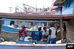 Para nelayan beristirahat di kapalnya di pelabuhan di Jakarta, 5 Mei 2019. (Foto: AFP)