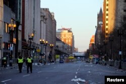 Two police officers walk down Boylston Street, away from the finish line of the Boston Marathon in Boston, Massachusetts April 16, 2013. Two bombs packed with ball bearings tore through crowds near the finish of the Boston Marathon, killing three people.