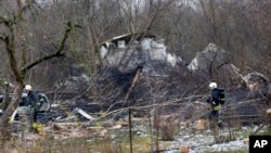 Službenici litvanskog ministarstva za vanredne situacije rade na mestu gde se teretni avion DHL-a srušio na kuću u blizini Vilnjusa, Litvanija, 25. novembar, 2024. (Foto: AP/Mindaugas Kulbis)