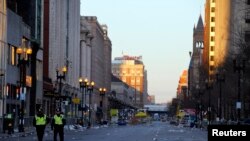 2013年4月16日，两名警察走在波士顿马拉松爆炸案现场附近的街道上。