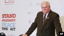 FILE - Former Polish president Lech Walesa is seen standing between chairs after a news conference in Warsaw, Poland, Oct. 20, 2013.