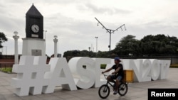 Seorang pria mengendarai sepeda melintasi logo ASEAN menjelang pertemuan Menteri-menteri Luar Negeri ASEAN ke 50 di Manila, Filipina, 2 Agustus 2017. 