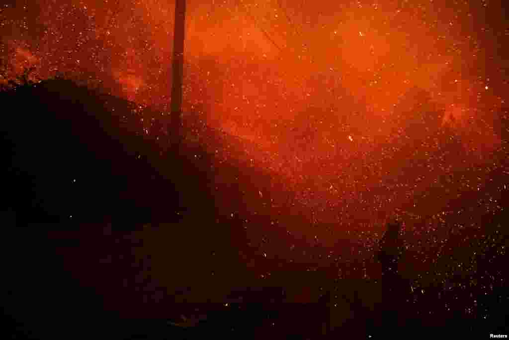 A firefighter stands among flying sparks as the Eaton Fire burns in Pasadena, California, Jan. 7, 2025. 