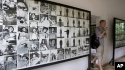 A tourist walks past photos of former prisoners displayed at Tuol Sleng genocide museum, a former Khmer Rouge prison known as S-21, in Phnom Penh.