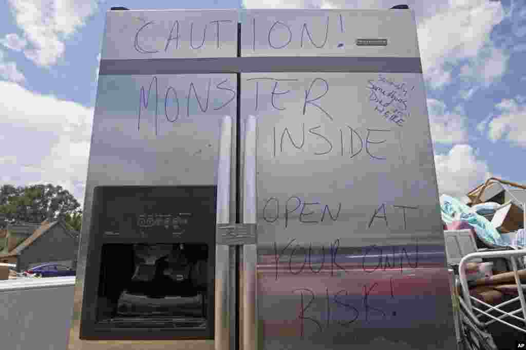 A warning sign is written on a flood-damaged refrigerator left on the side of the road in St. Amant, Louisiana, Aug. 20, 2016. 