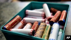 FILE - This Wednesday, July 15, 2020 file photo shows rolls of coins in a container at a market in Nanticoke, Pa. The Federal Reserve says the supply system for coins had been severely disrupted by the pandemic. (Sean McKeag/The Citizens' Voice via AP)