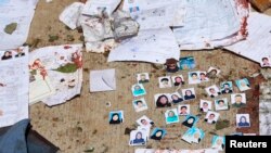 Blood-stained national ID papers and voters' photos are seen on the ground outside a voter identification card center after a suicide attack in Kabul, April 22, 2018.