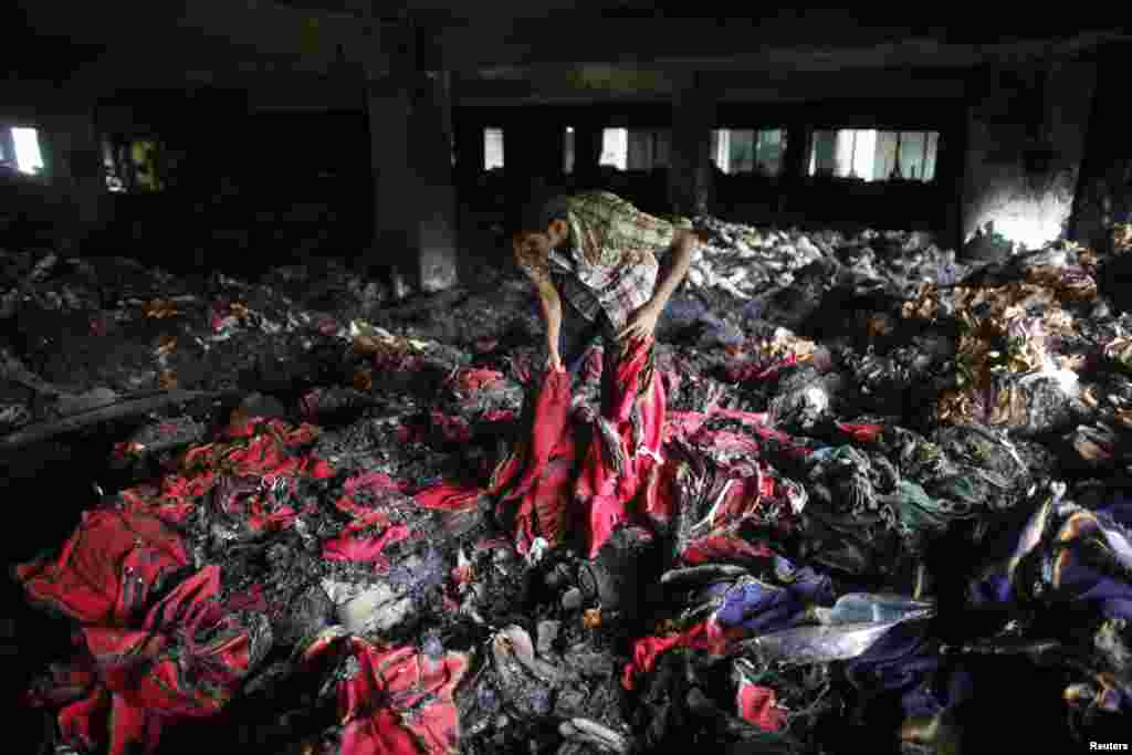 A garment worker inspects a factory after a fire, Dhaka, Bangladesh, May 9, 2013.