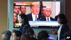 Warga melintas di depan layar TV di stasiun kereta api yang menayangkan rekaman Presiden AS Donald Trump dalam sebuah program berita. Seoul, Korea Selatan, 25 Mei 2018 (foto: AP Photo/Ahn Young-joon)