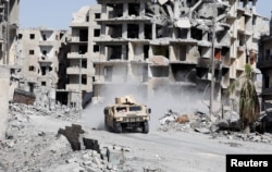 An armored vehicle of the Syrian Democratic Forces is seen along a road at the frontline in Raqqa, Syria October 8, 2017.