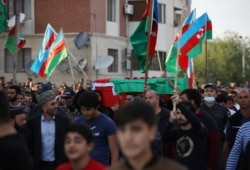 People carry the coffin of a member of Azerbaijani armed forces who was allegedly killed during the fighting over the breakaway region of Nagorno-Karabakh, in Tartar district, Sept. 29, 2020.