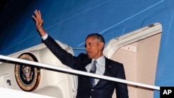 Presiden AS Barack Obama melambaikan tangannya ketika menaiki pesawat Air Force One (14/11) di pangkalan militer di Maryland.(AP/Pablo Martinez Monsivais)