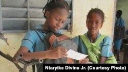 Two students prepare for classes at Marou Bi-Lingual High School in Cameroon.