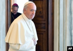 FILE - Pope Francis walks through at the Vatican, June 17, 2017.