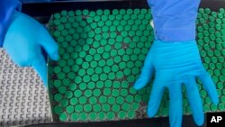 An employee packs a box containing vials of Covishield, a version of the AstraZeneca vaccine, at the Serum Institute of India in Pune, Nov. 22, 2021.