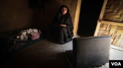 Rashida at home with a suitcase containing the clothes of her son Mohammed, 10, who vanished a month ago. (J. Owens/VOA)