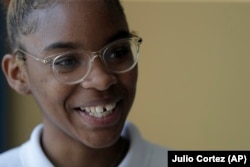 Tinazsha Johnson, 15, talks about her project on rice water during the science fair a New Song Community Learning Center in Baltimore, where she is learning to cope with her sorrow and stress.