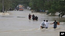Residents brave a raging floodwater brought about by Typhoon Nari at San Ildefonso township, Bulacan province, north of Manila, Philippines, Oct. 12, 2013.