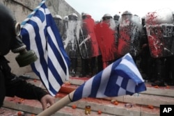 Greek riot police block the stairs leading to parliament during clashes after a rally in Athens, Jan. 20, 2019.