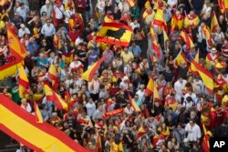 People wave Spanish national flags as thousands packed the central Cibeles square to in Madrid, Spain, Saturday, Sept. 30, 2017.