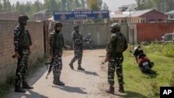 Indian paramilitary soldiers stand guard outside a government school where two teachers were shot dead by assailants in the outskirts of Srinagar, Indian-controlled Kashmir, Oct. 7, 2021.
