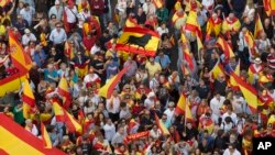 People wave Spanish national flags as thousands packed the central Cibeles square to in Madrid, Spain, Saturday, Sept. 30, 2017.