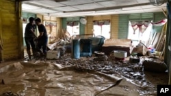 House owners clean up their home after the flooding at Hulu Langat, outskirt of Kuala Lumpur, Malaysia, Dec. 22, 2021. 