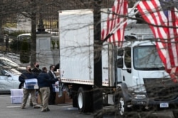 Workers move boxes from the Eisenhower Executive Office Building into a truck on the White House grounds in Washington, U.S., January 14, 2021. (REUTERS/Erin Scott)