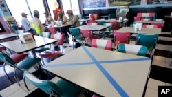 តុ​​​ខ្លះ​នៅ​ហាង​​អាហារ​ ​​Hwy 55 Burgers Shakes & Fries នៅ​ ក្រុង Nolensville រដ្ឋ Tennessee ត្រូវ​គេ​ខ្វែង​ចោល​​ដើម្បី​រក្សា​គម្លាត​សង្គម​កាលពី​​ចុង​ខែ​មេសា នៅ​ថ្ងៃ​ដំបូង​ដែល​រដ្ឋ​នេះ​បាន​អនុញ្ញាត​ឲ្យ​ភោជនីយដ្ឋាន​អាច​បើក​វិញ​បាន។